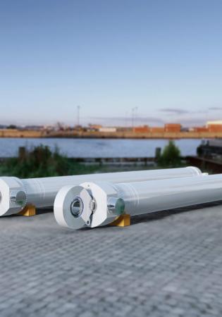 Two large custom hydraulic cylinders at riverside port in advance of being installed.