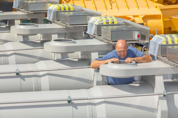 Large outlet gate hydraulic cylinders being inspected by engineer