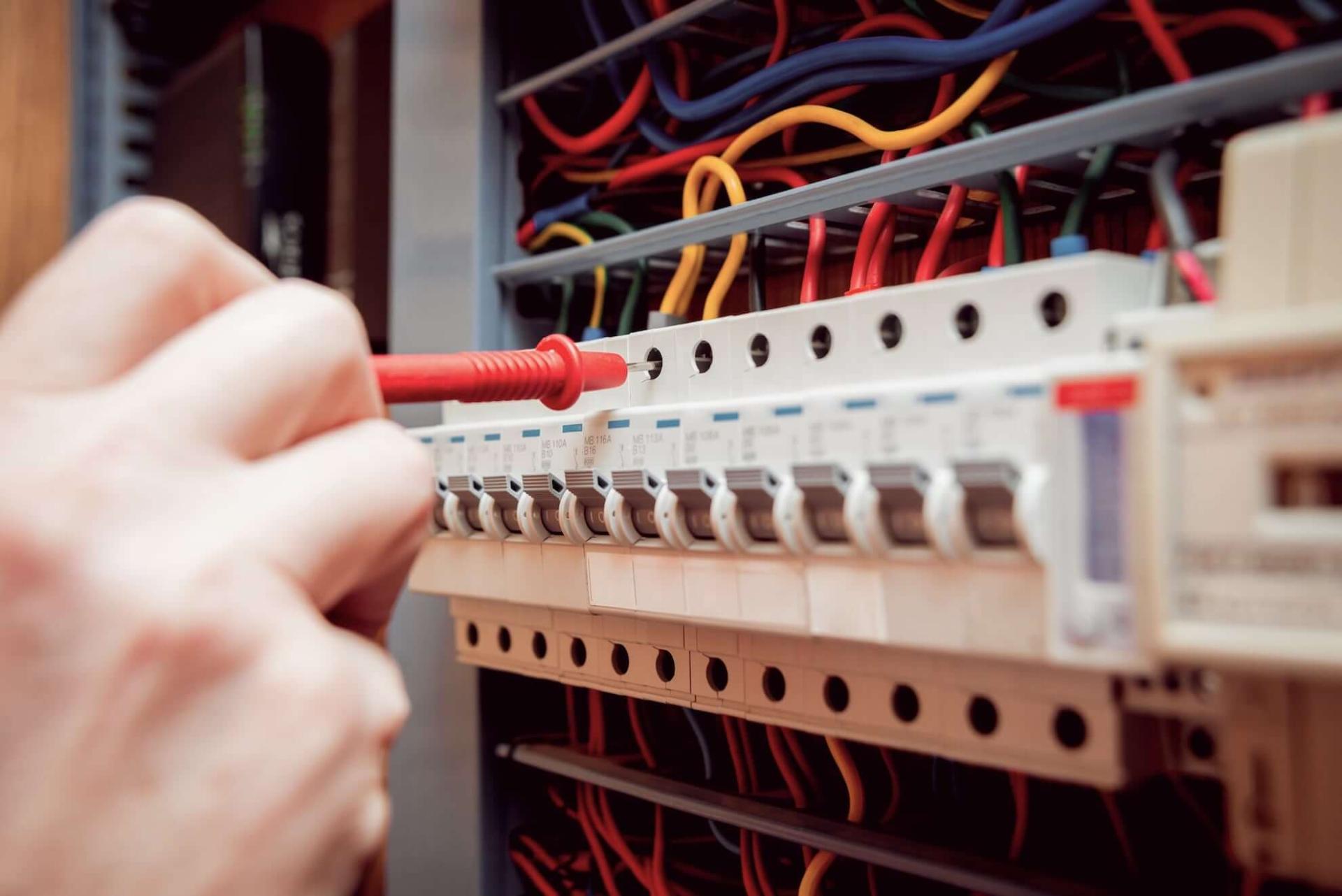 Close-up of new control system electric panel being shop tested with multi-meter. 