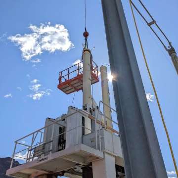 Two large hydraulic cylinders for a hydroelectric dam outlet gate being installed