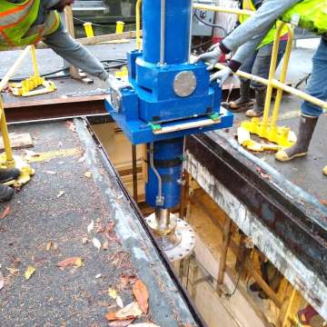 Custom large bore cylinder for hydraulic gate hoist being lowered into machinery room