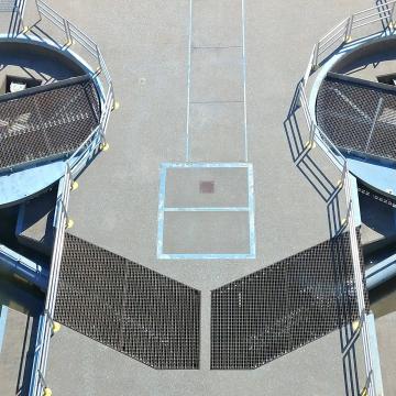 Miter gate hydraulic cylinder actuators in service at water control dam viewed from above